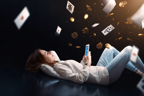 A young woman relaxing with her phone while dynamic casino elements float around her, illustrating the smooth mobile experience offered by the 77ABC app.