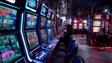 উজ্জ্বল স্লট মেশিনের পাশে হাস্যোজ্জ্বল এক নারী—যা 77ABC–এর রোমাঞ্চকর স্লট সংগ্রহকে উপস্থাপন করে।